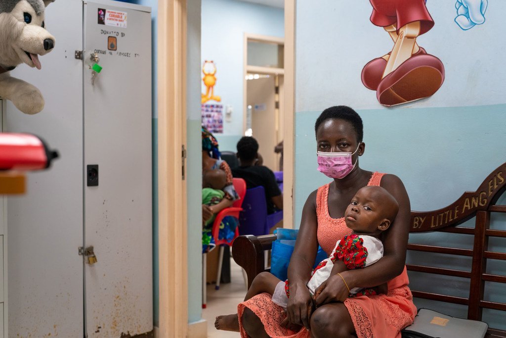A two-year-old girl and her mother wait to see a doctor at a pediatric oncology unit in Ghana.